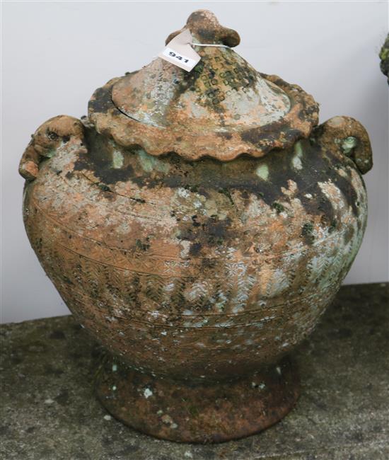 A weathered terracotta garden urn with cover, with elephants head finial, H.1ft 5in.
